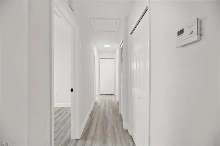 Corridor featuring attic access and light wood-type flooring