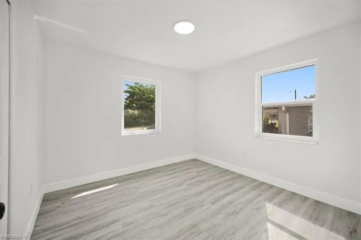 Empty room with baseboards and light wood-style floors