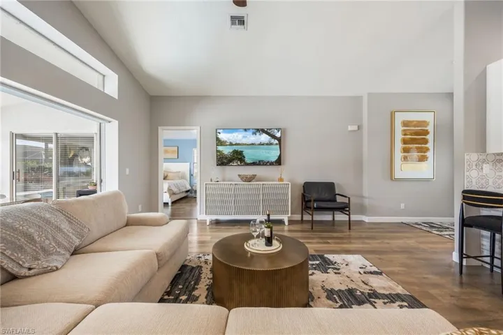 Living room with dark wood-style floors and high vaulted ceiling
