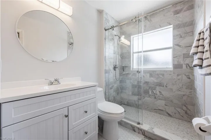 Full bath with a stall shower and vanity