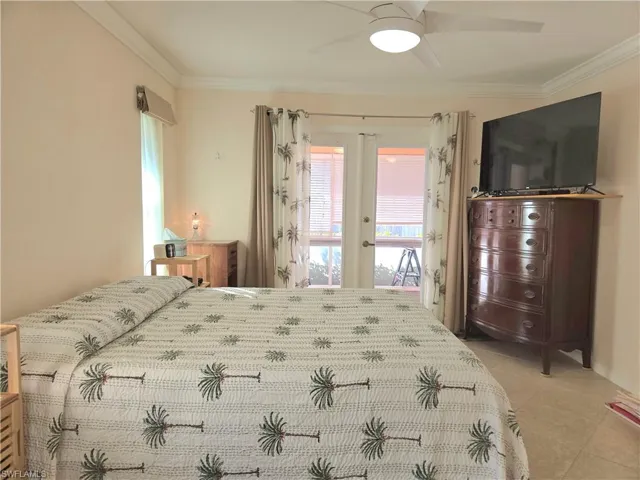 Bedroom with french doors, ceiling fan, crown molding, and light tile patterned flooring