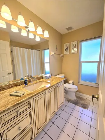 Bathroom with tile patterned flooring, vanity, and toilet