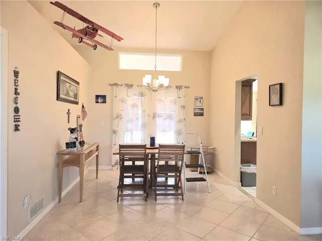 Dining area featuring light tile patterned floors and an inviting chandelier
