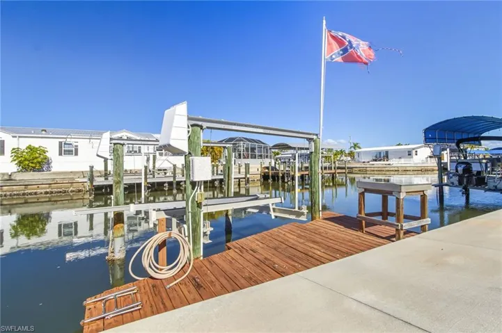 Dock area featuring boat lift and a water view