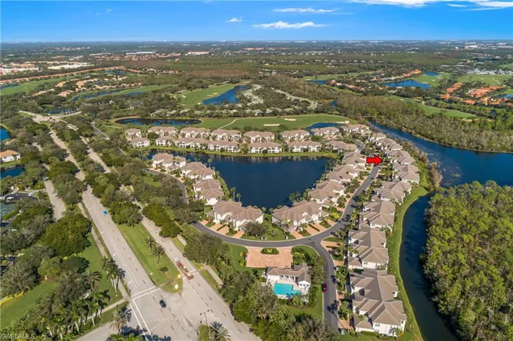 Aerial view of Cypress Hammock and building shown with red arrow, lanai facing east towards lake. Close to Amenity Center with pool, spa and clubhouse.