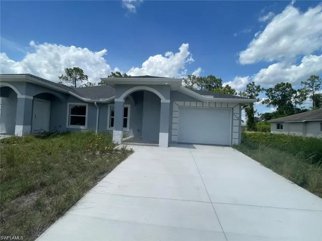 Ranch-style home featuring stucco siding, a garage, and driveway