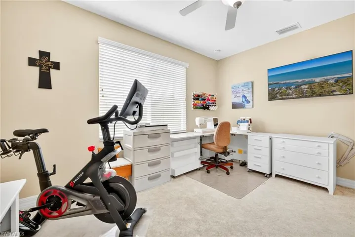Office area featuring light colored carpet and ceiling fan