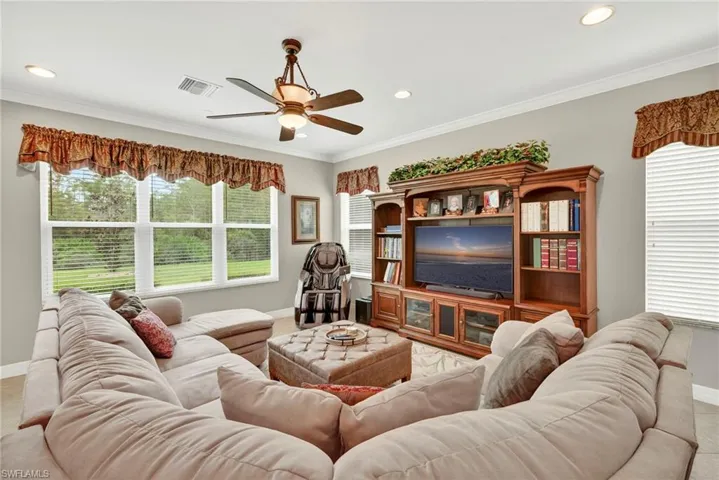 Living room with plenty of natural light, ornamental molding, ceiling fan, and recessed lighting