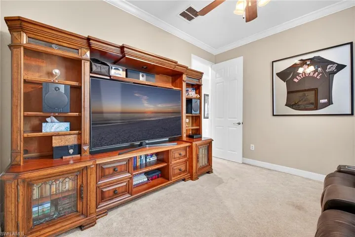 Office with light carpet, crown molding, and ceiling fan