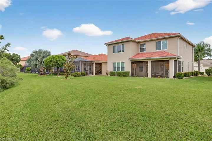 Back of property featuring a yard, a sunroom, and stucco siding