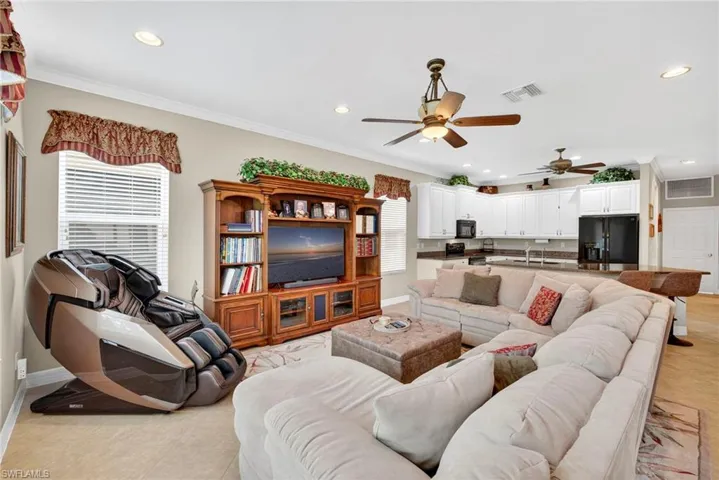 Living room featuring crown molding, recessed lighting, light tile patterned flooring, and a ceiling fan