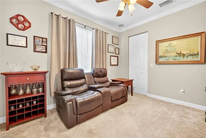 Sitting room with crown molding, light carpet, and a ceiling fan