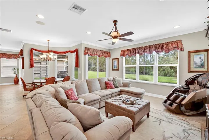 Living room with ornamental molding, a chandelier, recessed lighting, ceiling fan, and light tile patterned floors