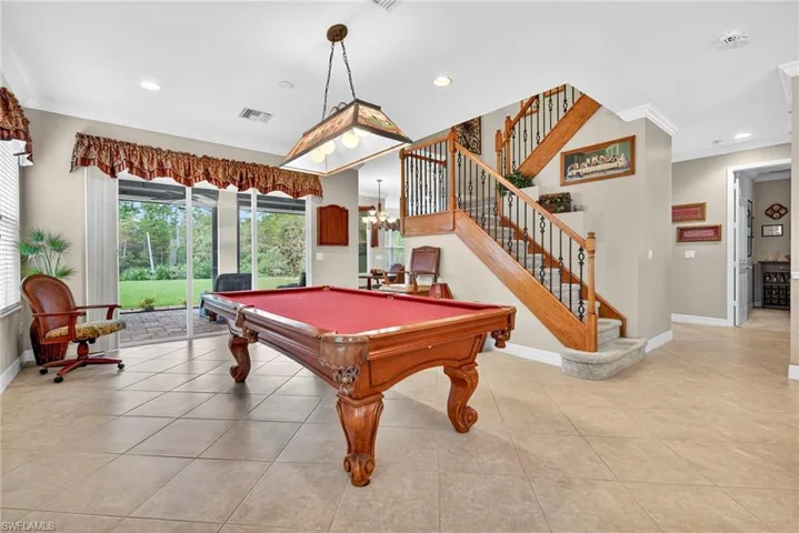 Recreation room with crown molding, light tile patterned floors, recessed lighting, billiards table, and a chandelier