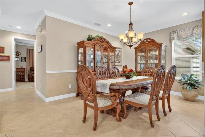 Dining space featuring ornamental molding, a chandelier, recessed lighting, and light tile patterned flooring