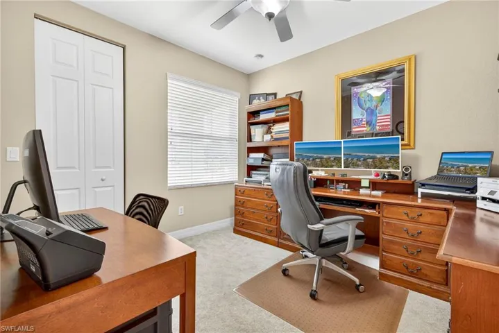 Office space with light carpet and a ceiling fan