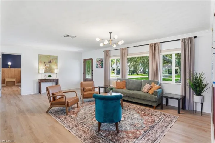Open concept living area featuring wood-finish flooring and a contemporary chandelier