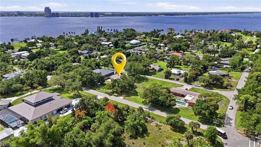 Aerial perspective of a residential neighborhood with lush green landscaping and mature trees