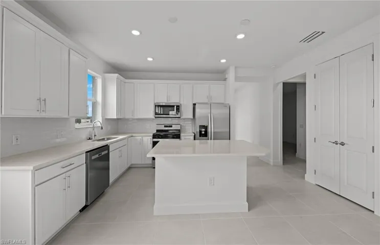 Spacious kitchen w/ island - quartz countertops and stylish backsplash