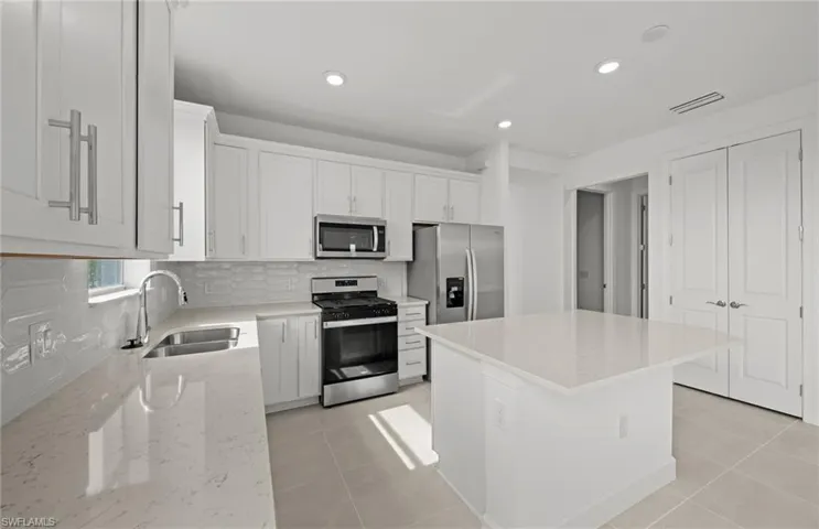 Spacious kitchen w/ island - quartz countertops and stylish backsplash