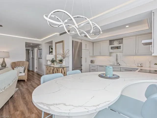 Dining room featuring ornamental molding, dark wood-type flooring, recessed lighting, and a chandelier