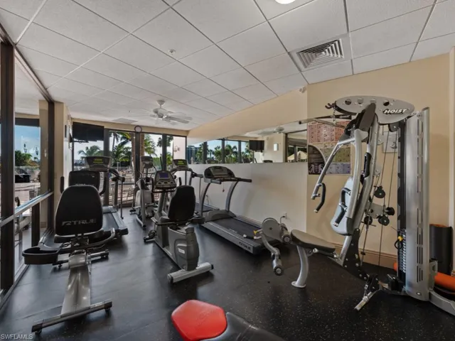 Gym with a paneled ceiling and a ceiling fan