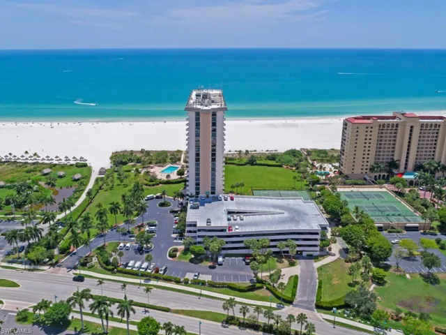 Drone / aerial view of unending shoreline and apartment complex / building