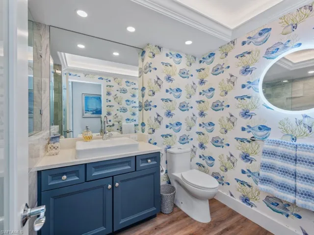 Full bath featuring wood finished floors, crown molding, vanity, and recessed lighting
