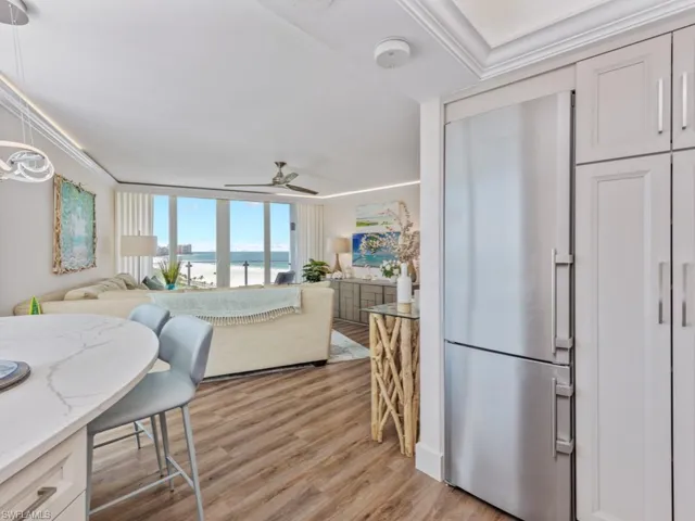 Dining room with a water view, light wood-style flooring, ceiling fan, and crown molding