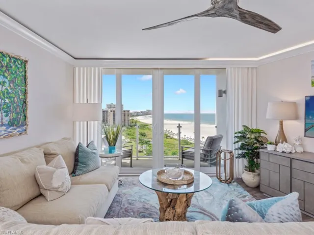 Living room with a ceiling fan, ornamental molding, and wood finished floors