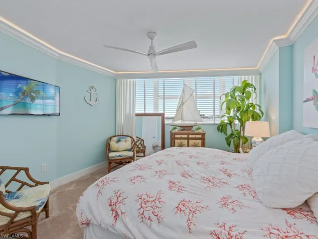 Carpeted bedroom featuring ornamental molding and a ceiling fan