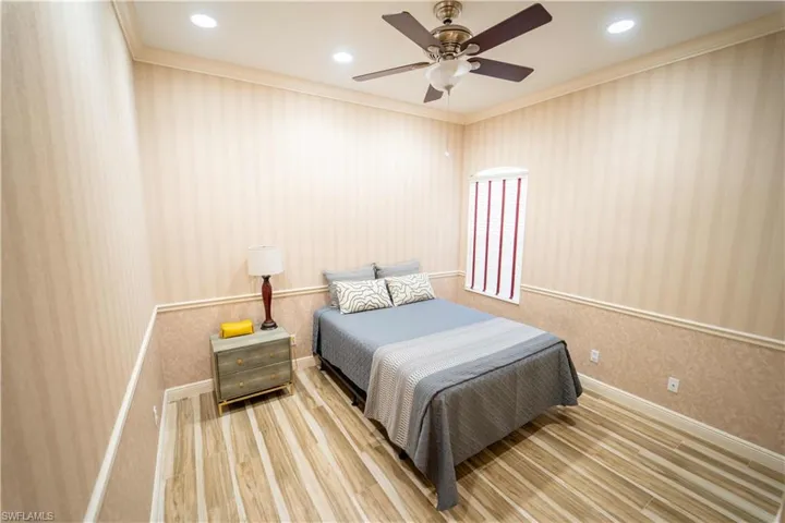 Bedroom featuring ceiling fan, hardwood / wood-style floors, and crown molding