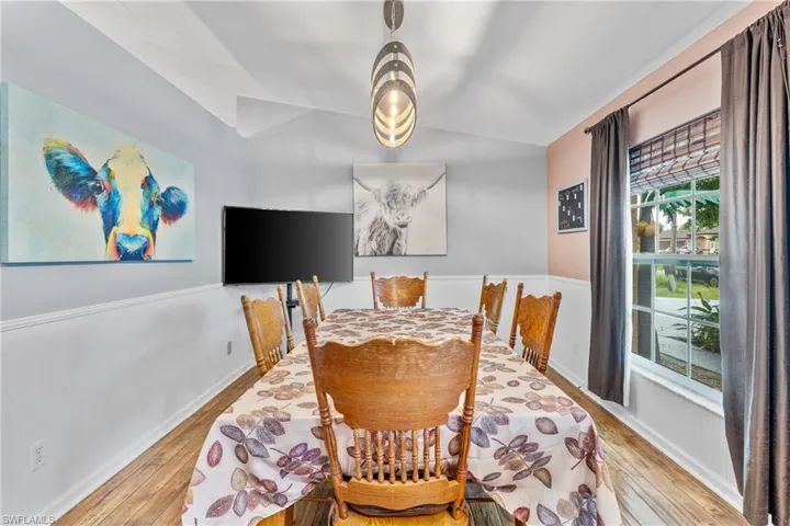 Dining space with hardwood / wood-style flooring and lofted ceiling