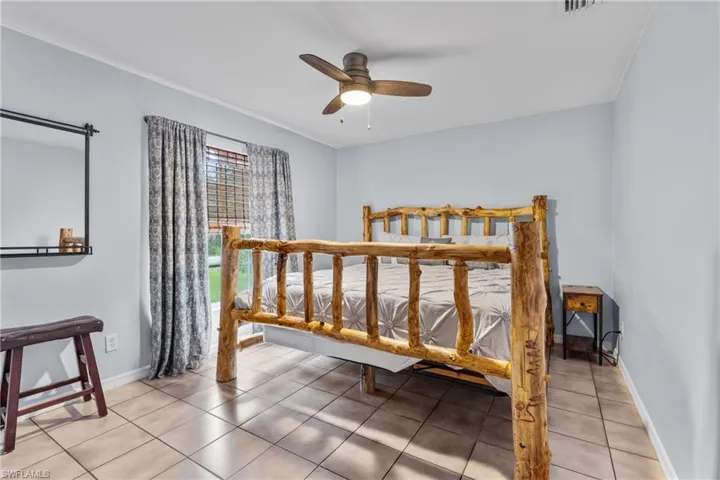 Bedroom with light tile patterned floors and ceiling fan