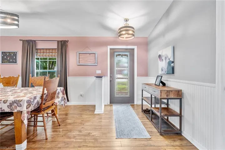Dining space featuring wainscoting, healthy amount of natural light, and wood finished floors