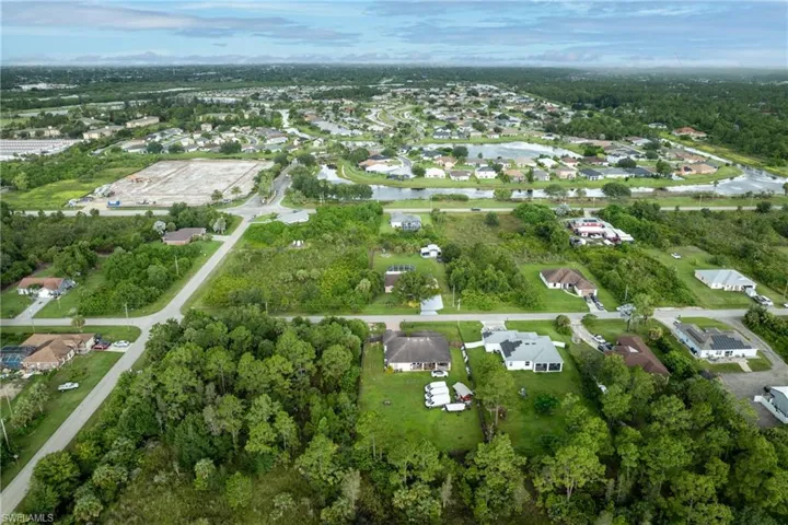 Aerial view of property's location with nearby suburban area and a nearby body of water