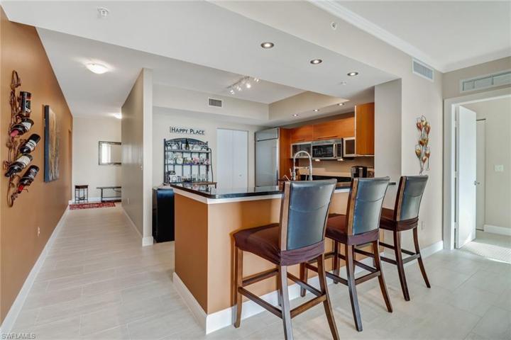 View from living area to kitchen and hallway that leads to den and second and third bedrooms