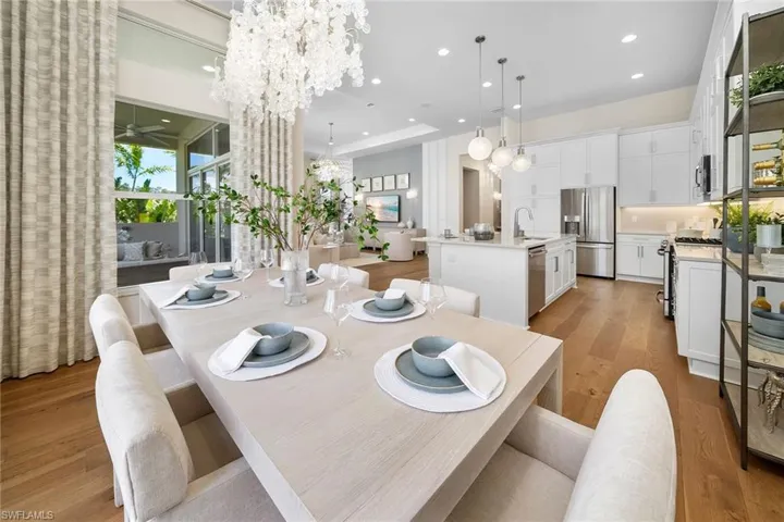 Dining area with light wood-style flooring, recessed lighting, a ceiling fan, and a chandelier