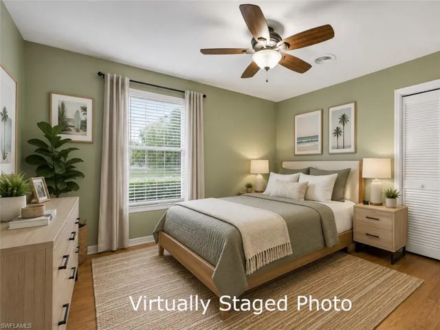 Bedroom featuring a ceiling fan with integrated lighting, wood-finish flooring, and a window with blinds