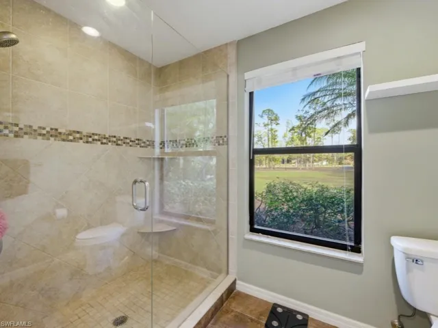 Bathroom featuring a shower stall and tile patterned flooring