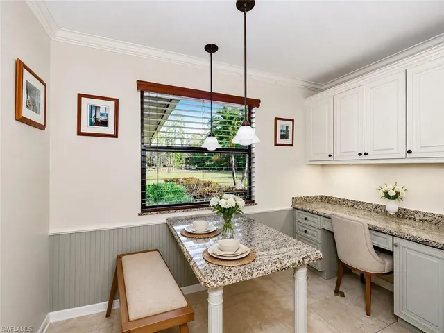 Kitchen nook featuring a granite-topped breakfast bar, beadboard wainscoting, and recessed lighting