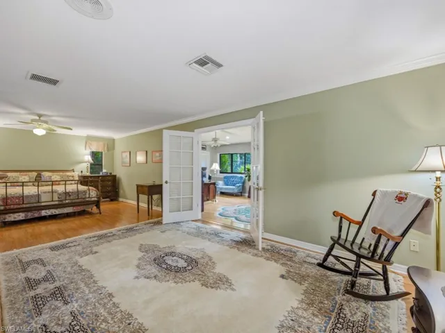 Bedroom featuring light wood-type flooring, ornamental molding, and french doors