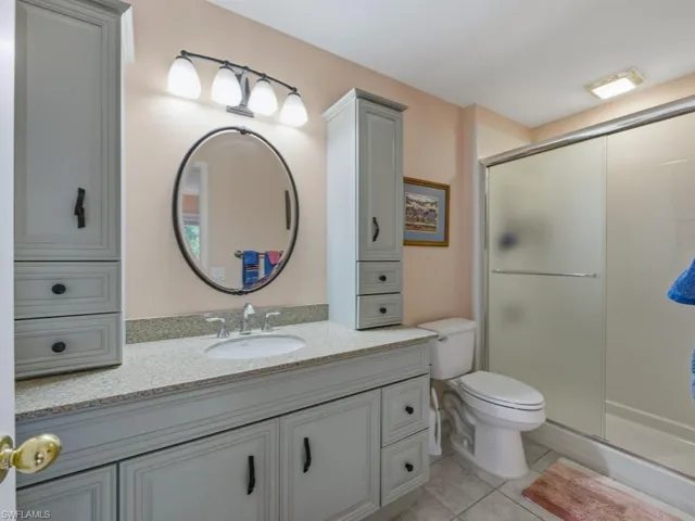 Full bath with vanity, a shower stall, and light tile patterned floors