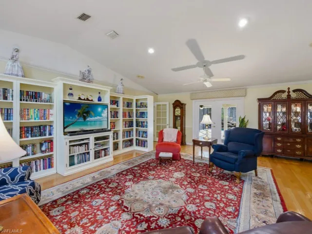 Living room with lofted ceiling, french doors, a ceiling fan, light wood-style flooring, and recessed lighting