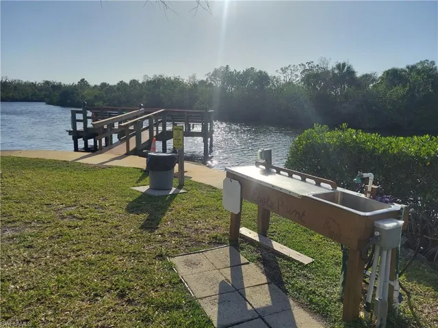 View of dock featuring a lawn and a water view