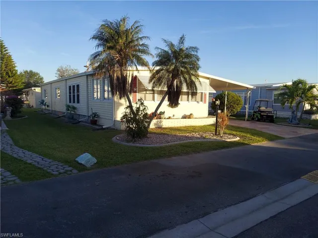 View of front of home featuring a front lawn and a carport