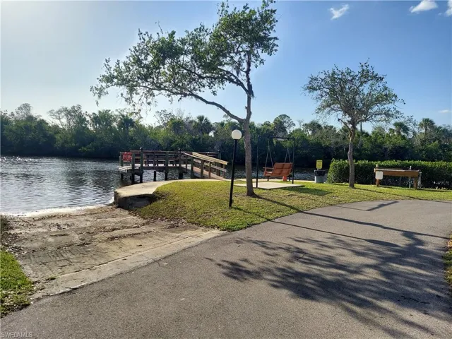 View of dock with a yard and a water view