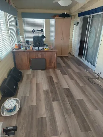 Home office with hardwood / wood-style flooring and crown molding