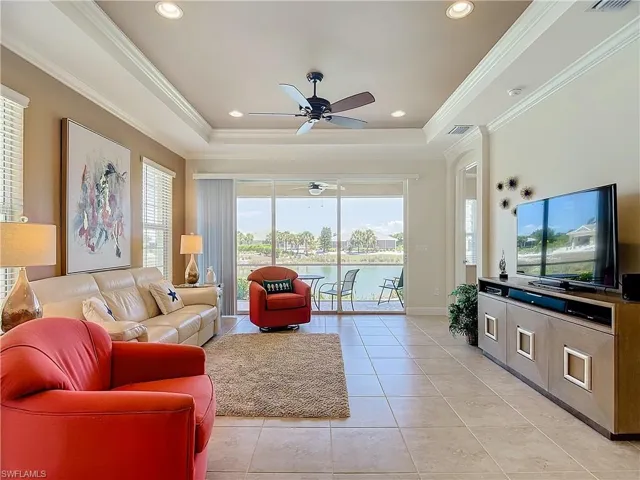 Living room featuring light tile floors, peaceful lake view and lovely furnishings