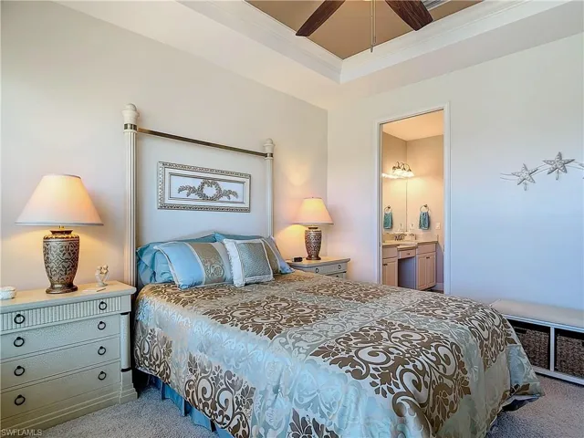 Bedroom with carpet flooring, ensuite bathroom, and ceiling fan